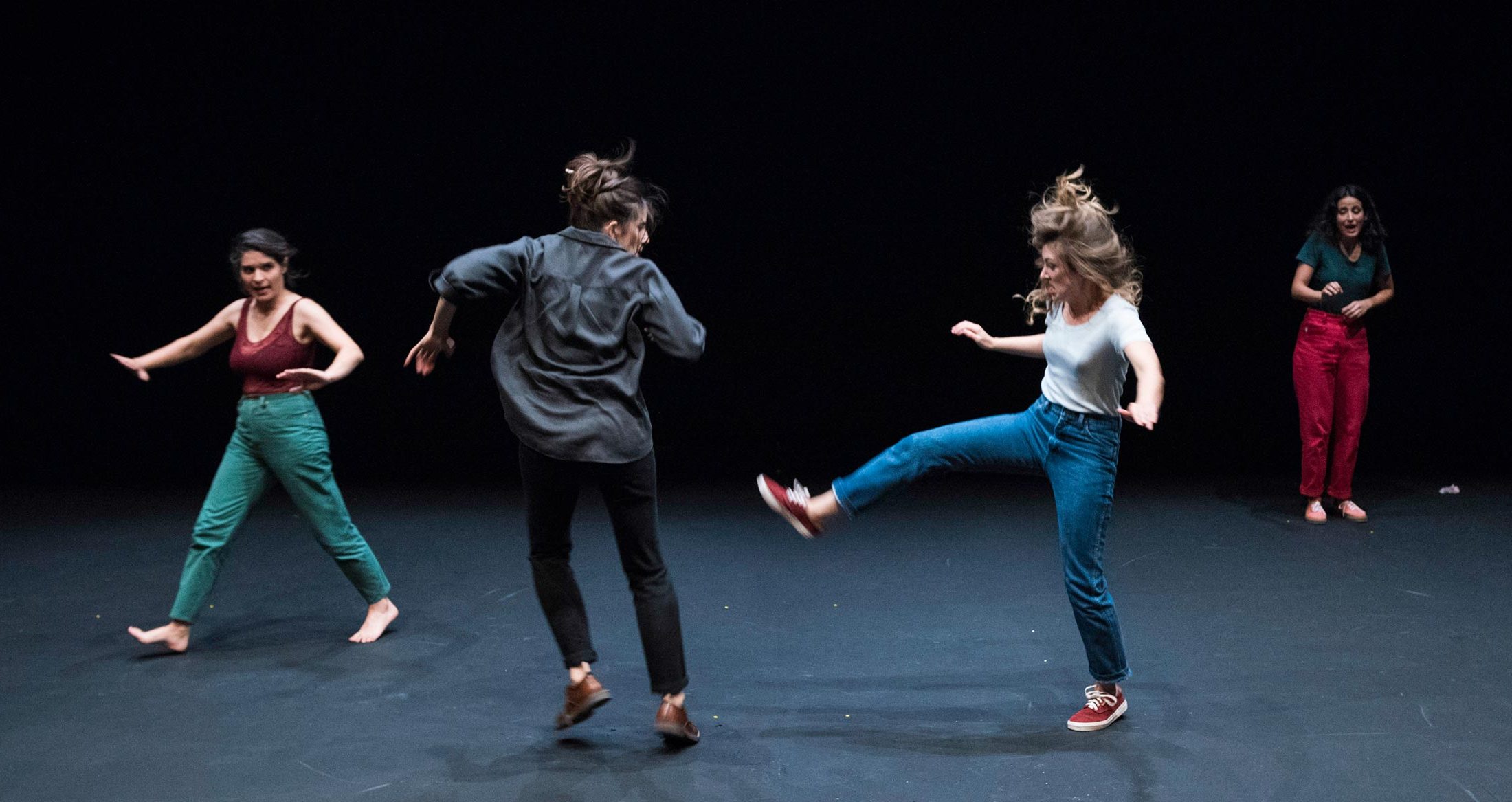 Niñas bailando en el escenario de teatro, demostrando alegría y movimiento en una actuación artística.