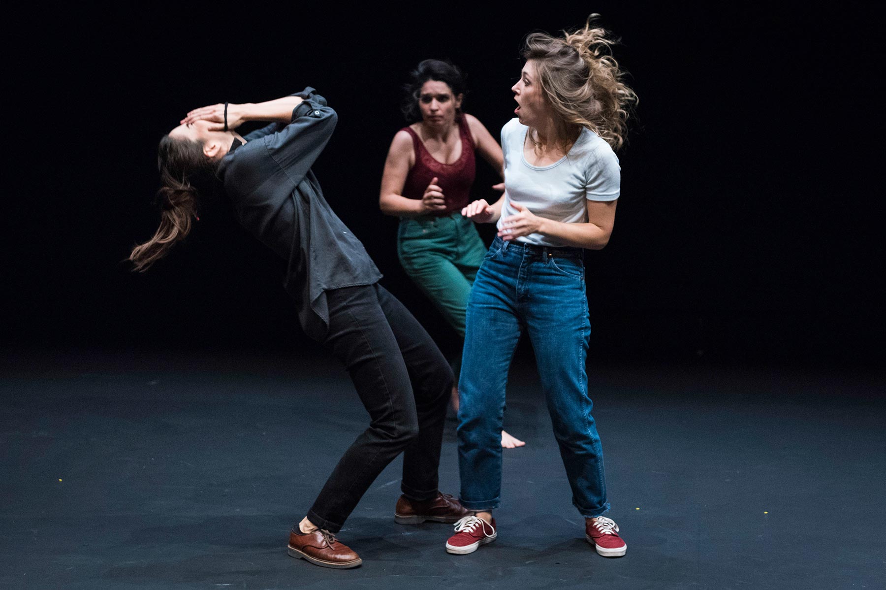 Danza contemporánea en escena con tres mujeres expresando emociones fuertes en un espectáculo teatral.