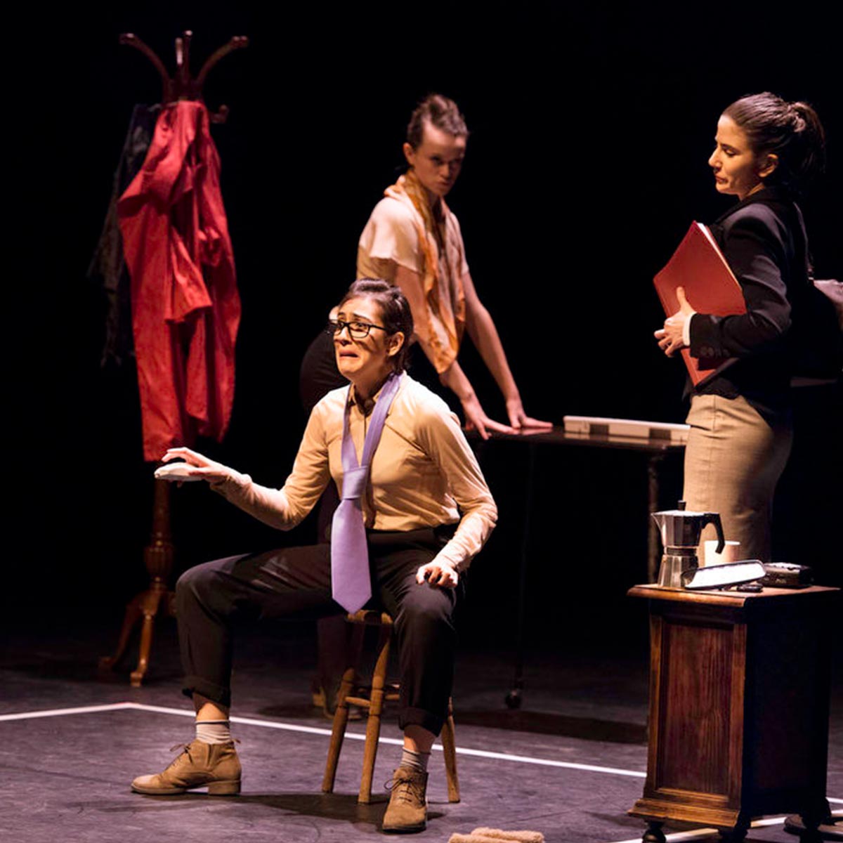 Maestra de teatro en escena con sus alumnas en un workshop o clases de actuación, en un teatro profesional, fomentando la creatividad y la expresión artística en las artes escénicas.