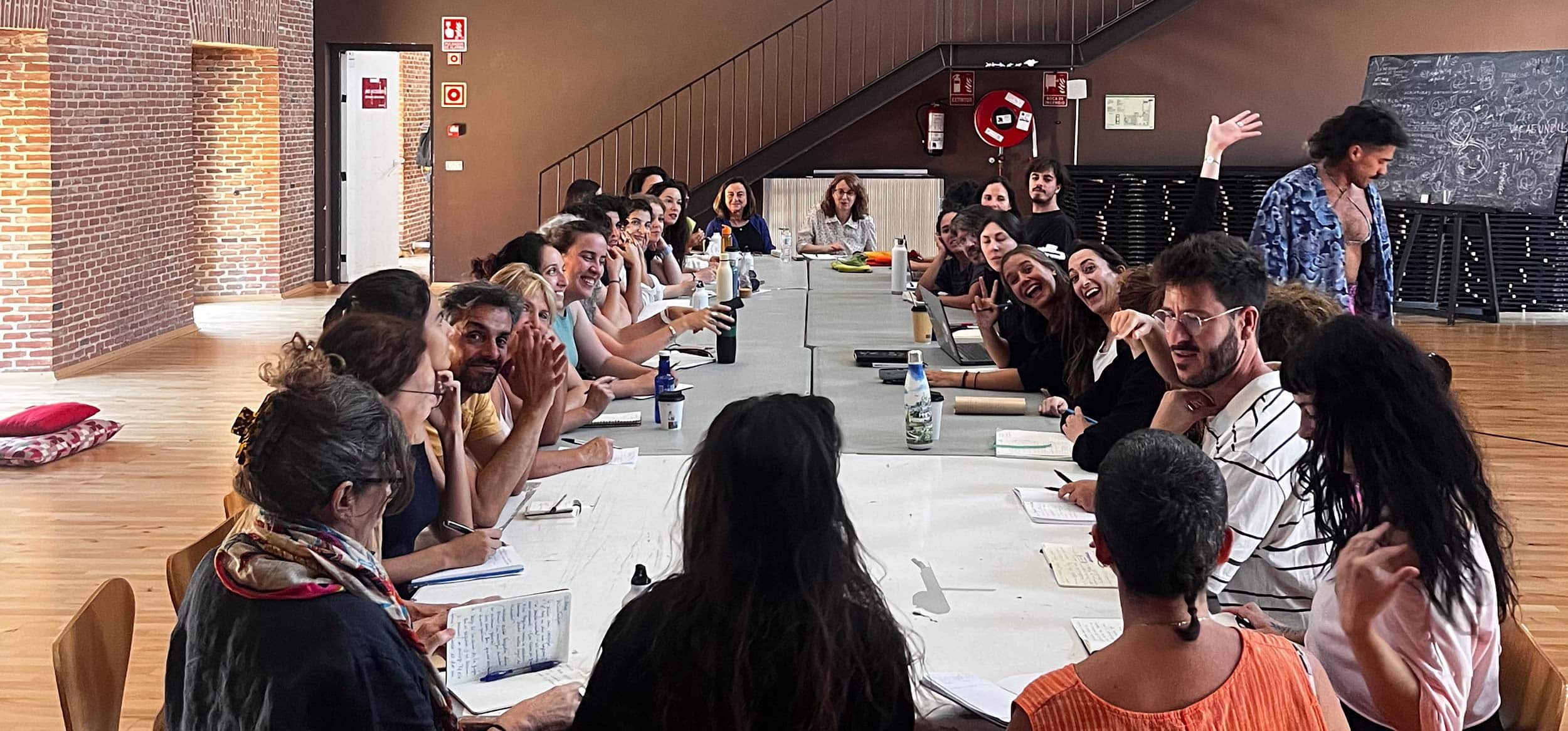 - Personas participando en una reunión de trabajo en un espacio moderno y bien iluminado.