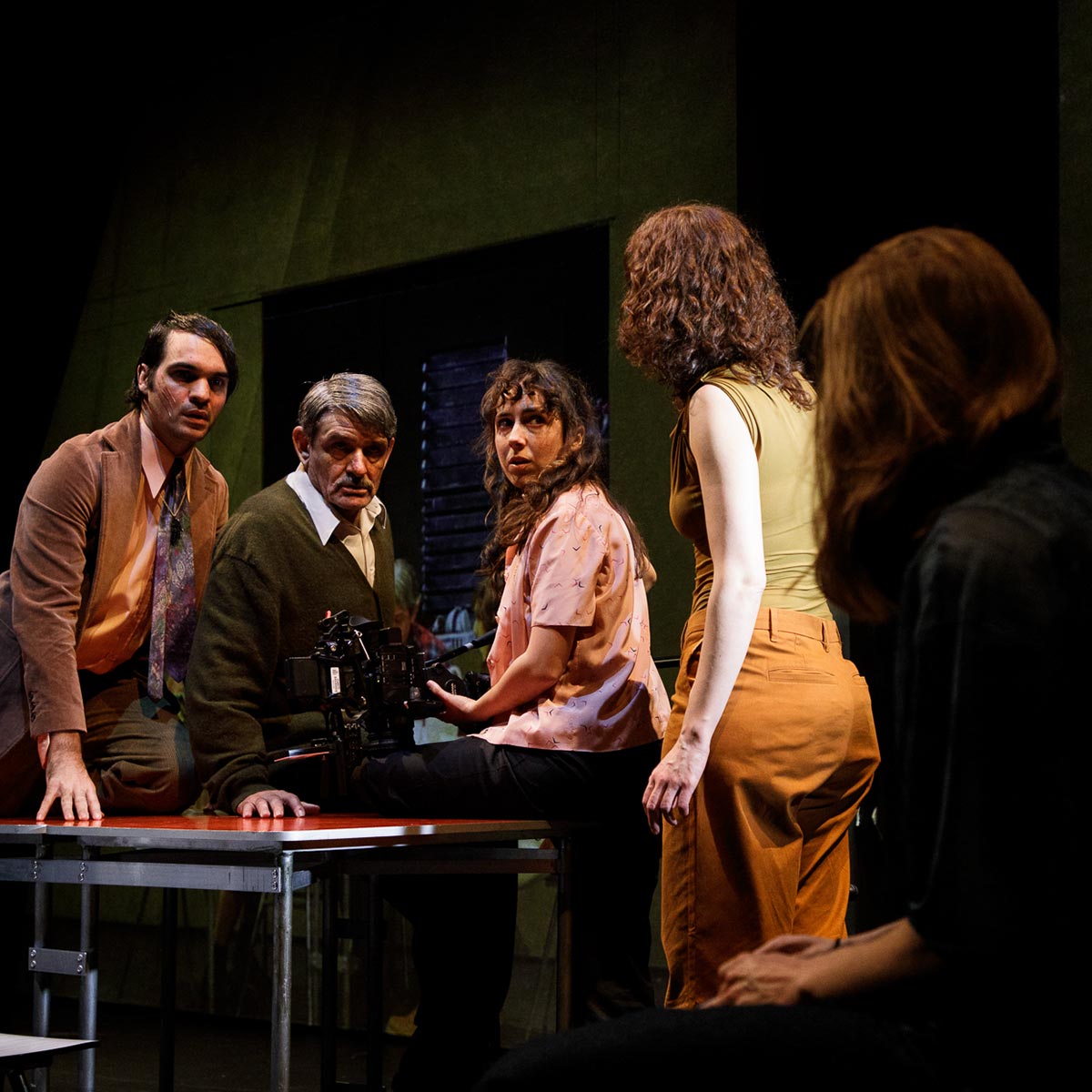 Vídeo de Andrea Jiménez mostrando actores en una escena teatral con atención intensa y expresión emocional, en el escenario con fondo oscuro y privacidad en el entorno teatral.