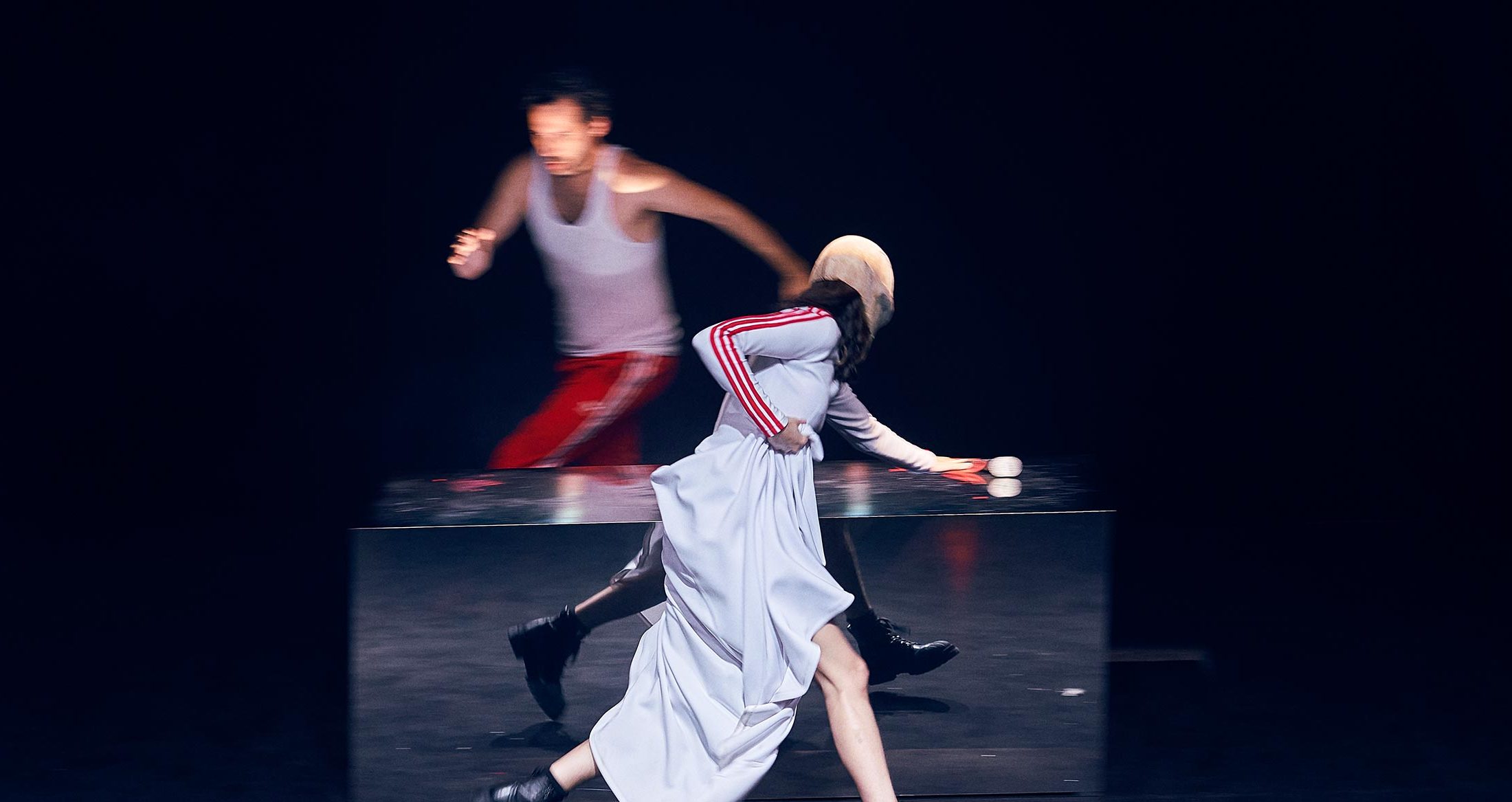 Degradado de escenas de teatro con actores en movimiento en escena oscura, esfuerzo dramático, arte teatral, interpretación artística, fotografía en vivo de espectáculo teatral.