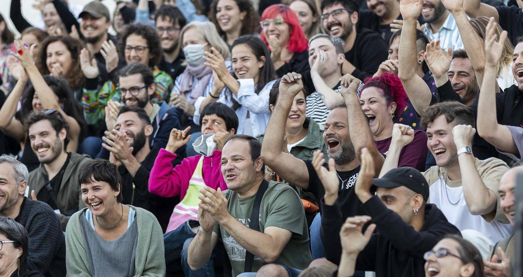 Diversión y alegría en evento social con grupo diverso de personas sonriendo, riendo y disfrutando de la compañía en una reunión al aire libre.